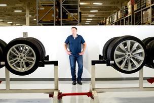 CEO Elon Musk stands with Model S wheels at Tesla's plant in Fremont, Calif.