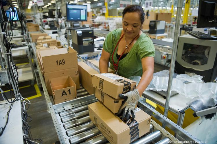 Job At Amazon An Amazon employee loads boxes onto a conveyer belt for shipping at the Amazon.com