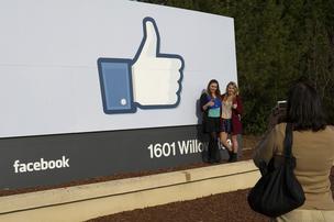 Tourists take photos of the Facebook Inc. 'like' logo displayed on a sign at the entrance to company headquarters in Menlo Park. Facebook is moving ahead with construction on its West Campus expansion.