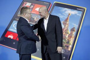 Steve Ballmer, chief executive officer of Microsoft Corp., right, and Stephen Elop, chief executive officer of Nokia Oyj, shake hands after a presentation of the new Nokia Lumia 920 smartphone at a news conference in 2012 in Moscow. Elop will receive a compensation package worth about $25.5 million when he rejoins Microsoft as an executive.