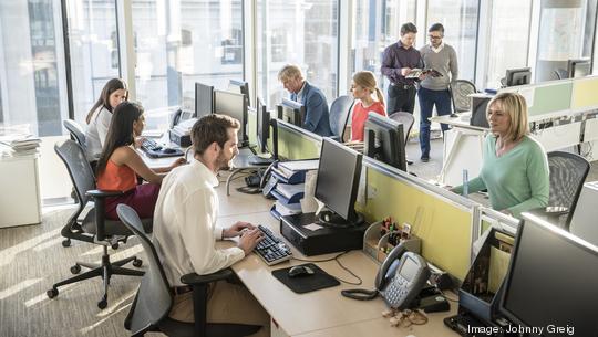 Office workers at desks using computers in modern office