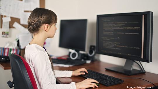 Little girl learning to code on desktop computer at home