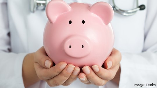 Female Doctor Holding Piggy Bank