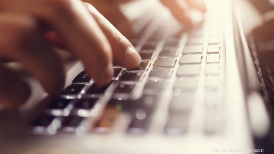 Hands typing on laptop computer