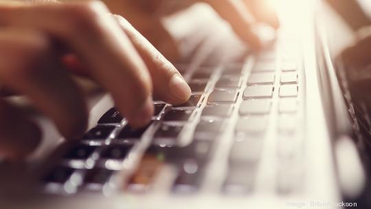 Hands typing on laptop computer