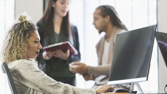 Mixed race woman in office using computer