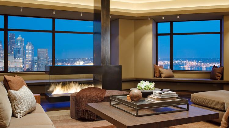 A show-stopping penthouse with unparalleled wraparound views at Bay Vista Tower in Seattle's Belltown has just hit the market for $13.8 million. The bronze, glass and steel fireplace in this living area is one of three fireplaces in the penthouse, including one in the master suite.
