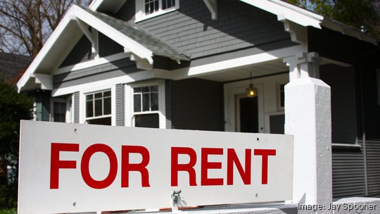 For rent sign in front of gray and white home