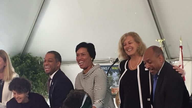 Councilman Brandon Todd, D-Ward 4 (second from left), D.C. Mayor Muriel Bowser (center) and Vicky Davis, Urban Atlantic president (second from right) and community members dig in at the Parks at Walter Reed on April 24, 2017.