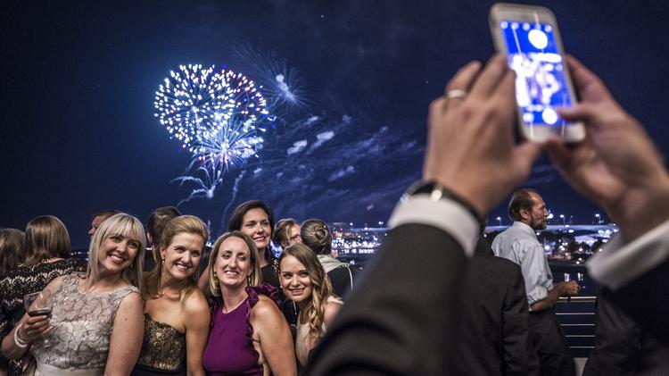 Guests take a photo with fireworks in the background at the Discovery World Gala July 29.