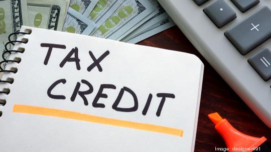 Notebook with tax credit  sign on a table. Business concept.