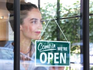 Female coffee shop owner opening the shop