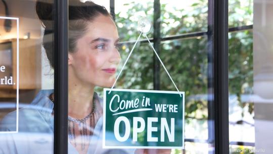 Female coffee shop owner opening the shop