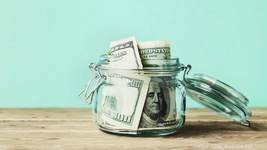 Dollar bills in glass jar. Saving money, economy, finance concept.