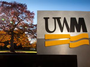 Campus scene showing fall colors and UWM signage.