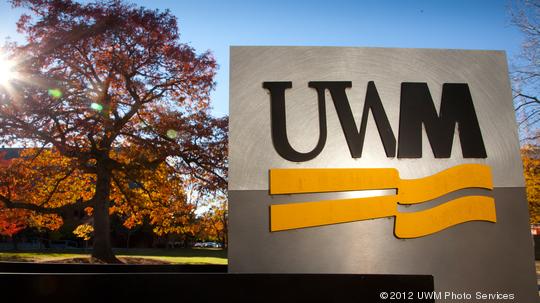 Campus scene showing fall colors and UWM signage.