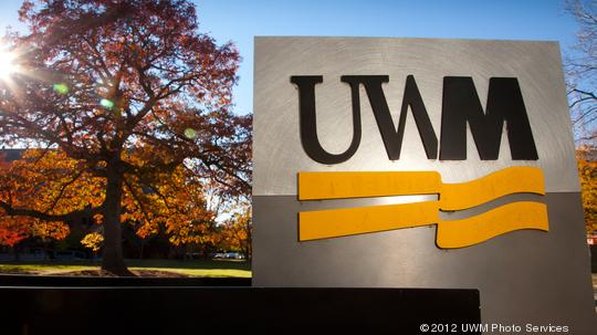 Campus scene showing fall colors and UWM signage.