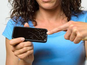 Midsection Of Woman Pointing At Broken Mobile Phone Display