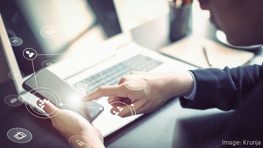 Businessman hand working with mobile phone and laptop computer  with technology digital graphic