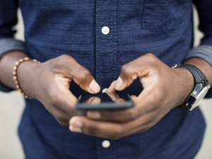 Midsection of man using mobile phone