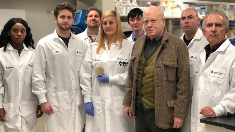 Dr. Carl Merril, third from right, with his son Greg, CEO and co-founder of Adaptive Phage Therapeutics, and other members of the team.
