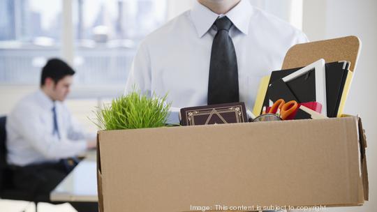 Fired Caucasian businessman carrying personal belongings