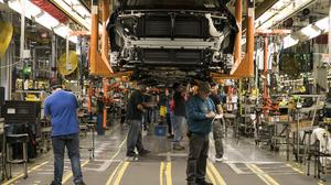 Assembly line workers make final adjustments on the undercarriage of vehicles at the General Motors Lansing Delta Township Assembly plant in Lansing, Mich., March 6, 2017.