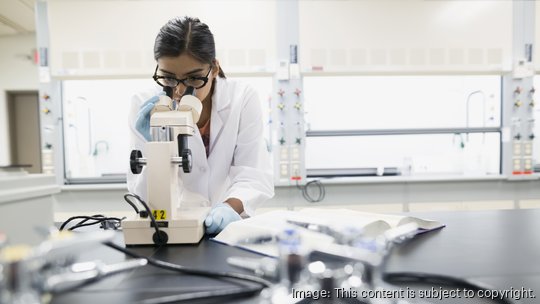 Scientist using microscope in laboratory