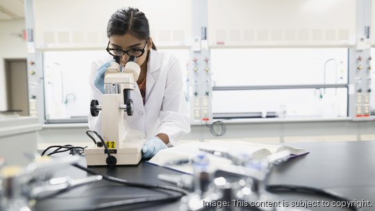 Scientist using microscope in laboratory