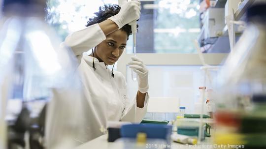 Black female scientist pipetting in a laboratory