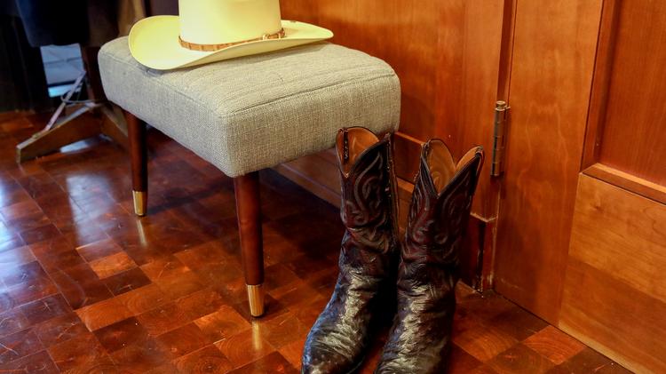 A cowboy hat and boots are prepared for Red McCombs at his office.