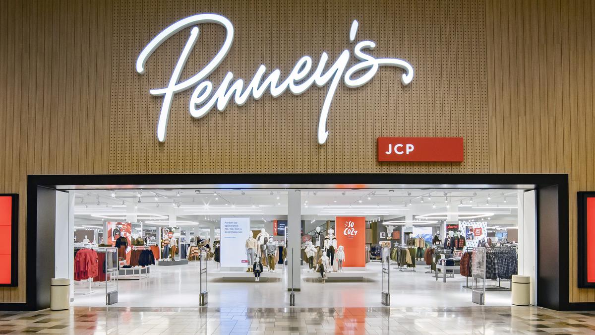 C. Penney logo is pictured on a bag as a customer shops nearby in