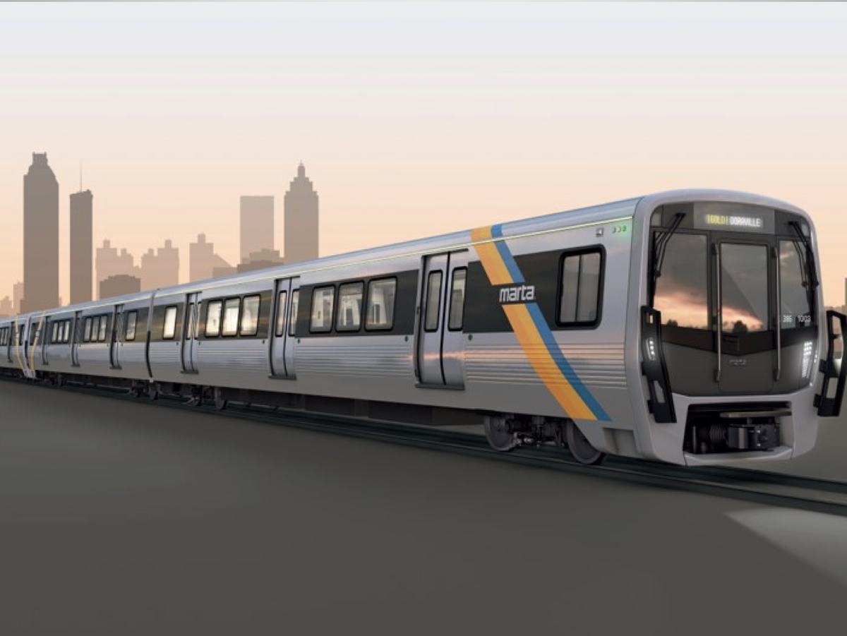 A silver train car with the MARTA insignia emblazoned on the side enters a station.