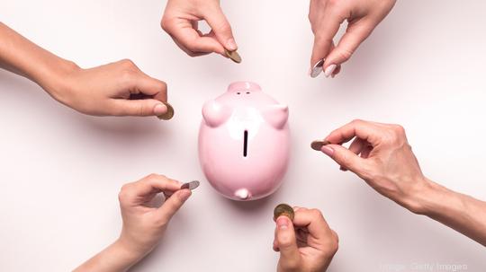 People hands throwing coins in piggy bank for crowdfunding