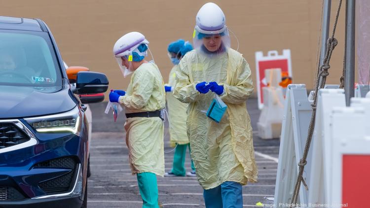 Medical personal administer COVID-19 tests at a testing site at in Philadelphia run by Penn Medicine.