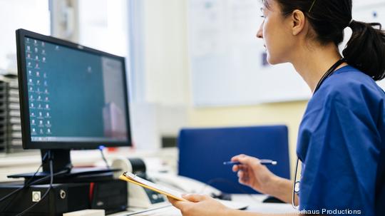 Female Mature Doctor Working On Computer