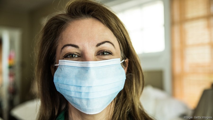 Woman wearing surgical mask and smiling