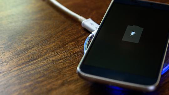 Smartphone charging on a charging pad. Wireless charging