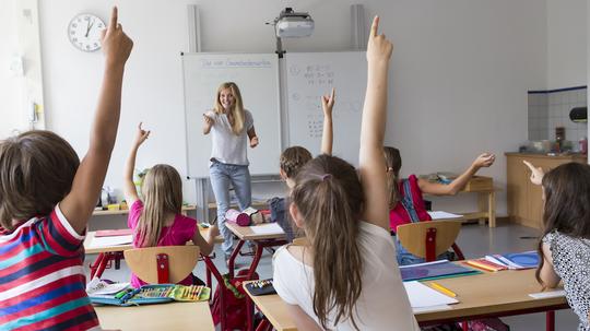 Active pupils raising their hands in class