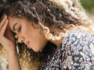 Mixed Race woman rubbing forehead