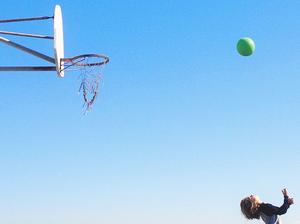 Boy shooting hoops on basketball court, California, America, USA