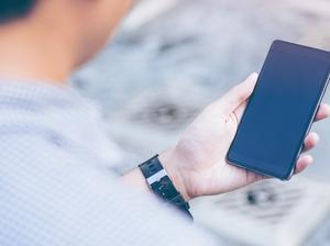 Young asian handsome businessman concentrated while reading his smartphone.