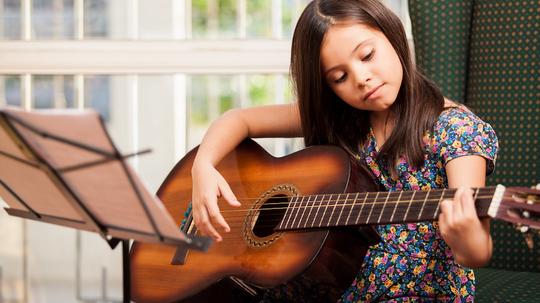 Girl plays guitar (image via Care2Rock)