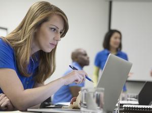 Focused female physiotherapist with laptop training in conference room meeting