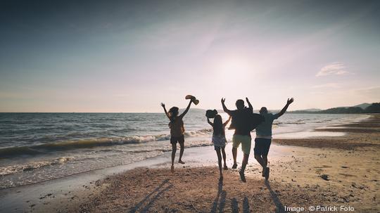 Asian family running on beach