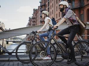 Germany, Hamburg, couple riding electric bicycles at Old Warehouse District