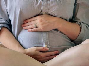 Pregnant Woman Sitting On Bed