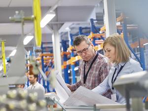 Supervisor and engineer discussing plans in fiber optics factory