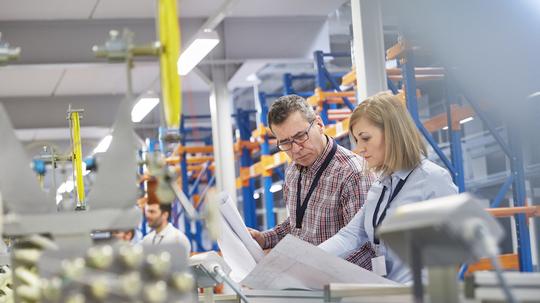 Supervisor and engineer discussing plans in fiber optics factory