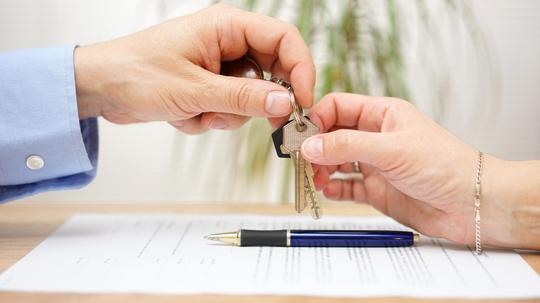 real estate agent gives house keys to his client